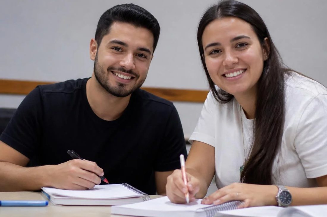Colegas de trabalho de pé no corredor, conversando no intervalo entre reuniões